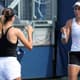 Bia Maia de branco com Danilina de costas na 2ª rodada do US Open