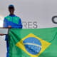 Jonathan Cruz, com a placa em homenagem a Luiz Antônio dos Santos dada pela Meia Maratona de Buenos Aires, e a treinadora Adriana Aparecida da Silva. (Divulgação)