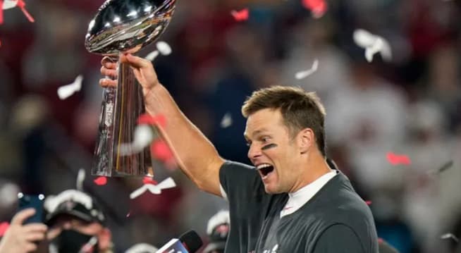 Tom Brady, maior vencedor de Super Bowls da NFL, segurando o trofeu Vince Lombardi