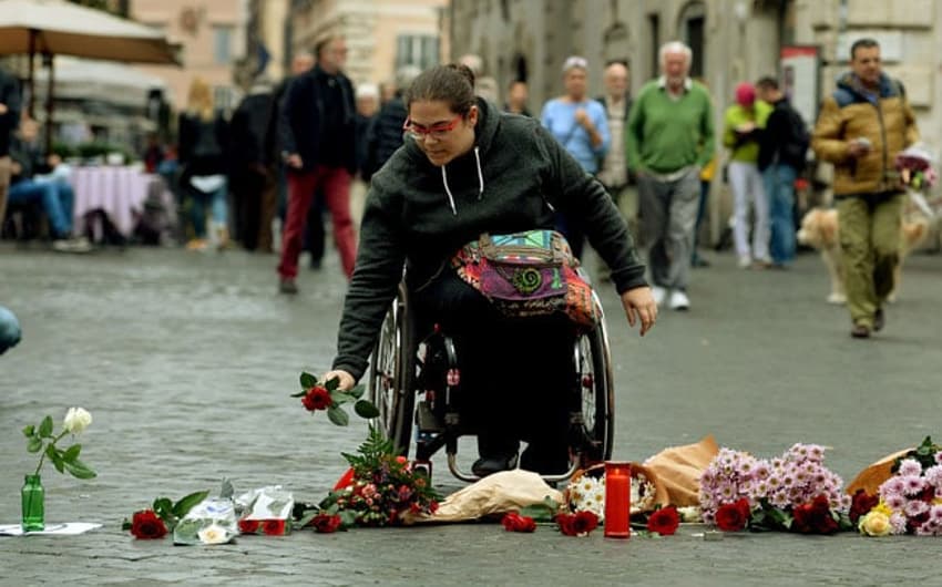 Mulher presta homenagem às vítimas dos atentados em Paris (Foto: AFP)