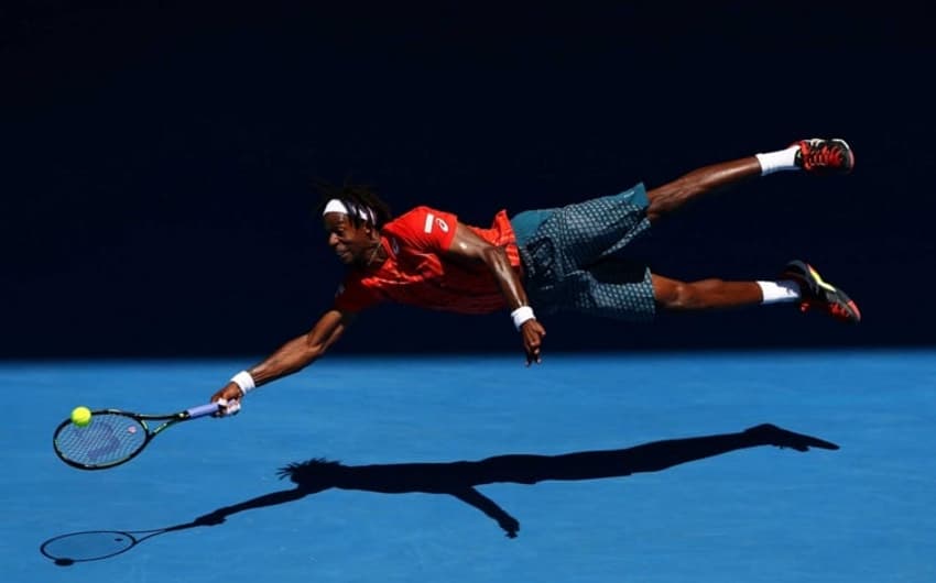 Gaël Monfils voa para salvar bola em Melbourne. Foto: Tennis Australia/Ben Solom