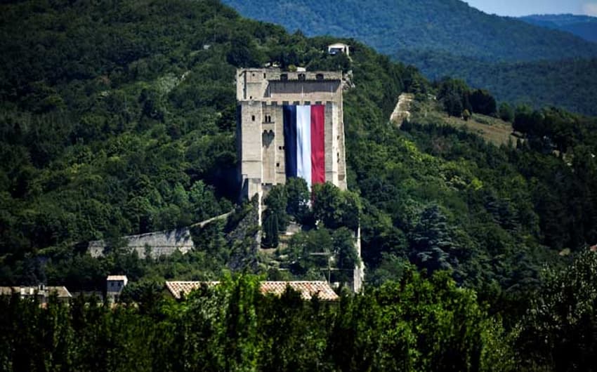 Bandeira da França aberta em um castelo para passagem dos ciclistas. Ato de protesto contra o terror