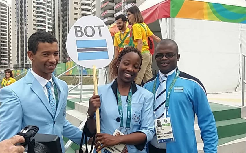 Atletas de Botswana chegam para a cerimônia de lahasteamento de bandeiras na Zona Internacion