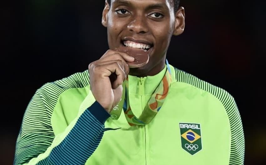 Maicon Siqueira morde a medalha de bronze conquistada<br>