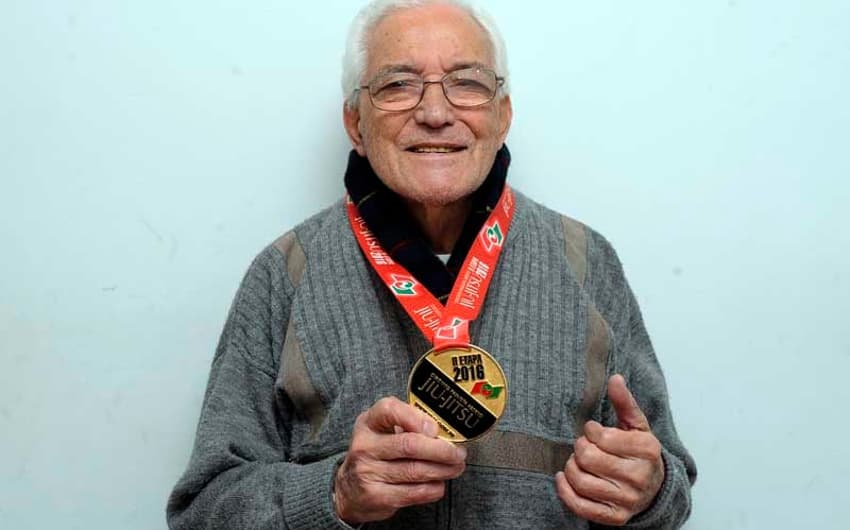 Seu Gerardo, de 89 anos, mostra medalha no jiu-jítsu