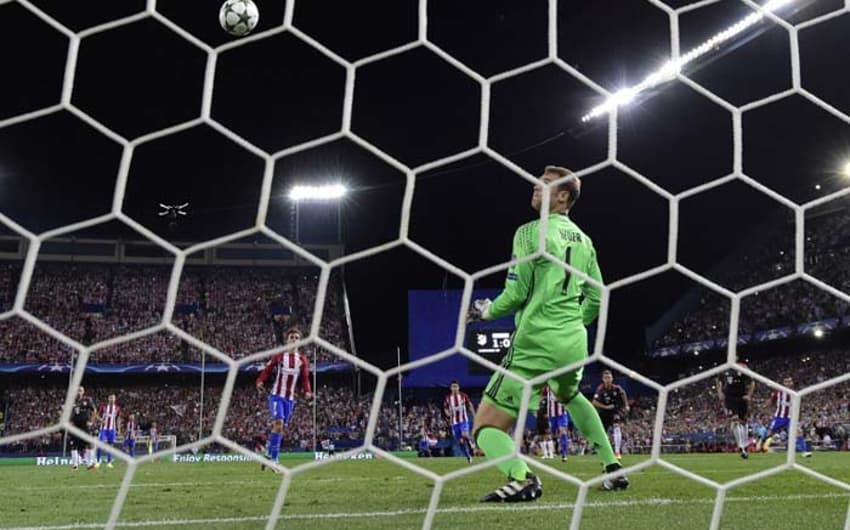 Manuel Neuer observa a bola em um perigoso golpe de vista na derrota do seu Bayern para o Atlético de Madrid
