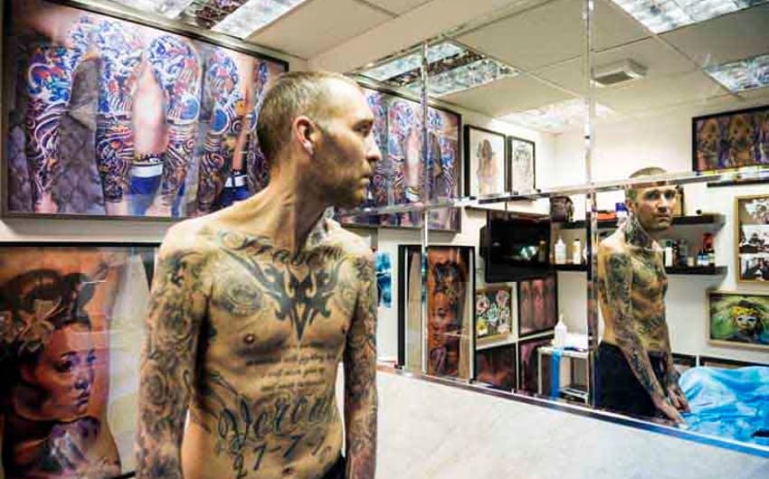 Fernando Ricksen, posa para foto mostrando o corpo tatuado