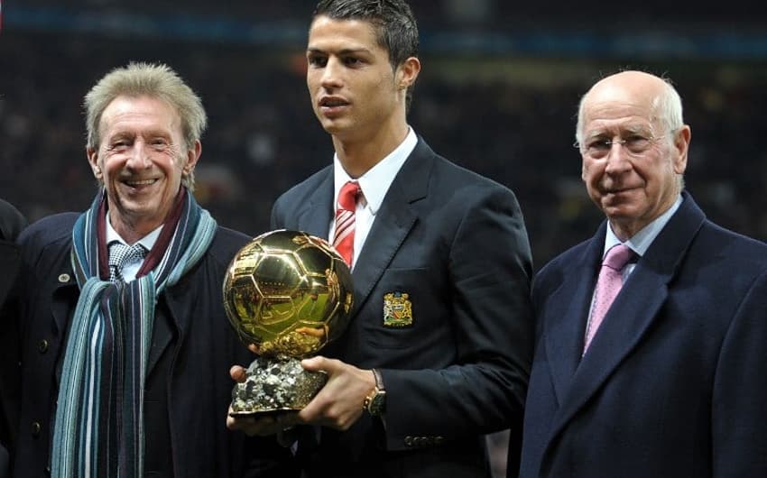 Ao lado de Dennis Law e Bobby Charlton, Cristiano Ronaldo recebe a Bola de Ouro de 2008, ainda pelo Manchester United