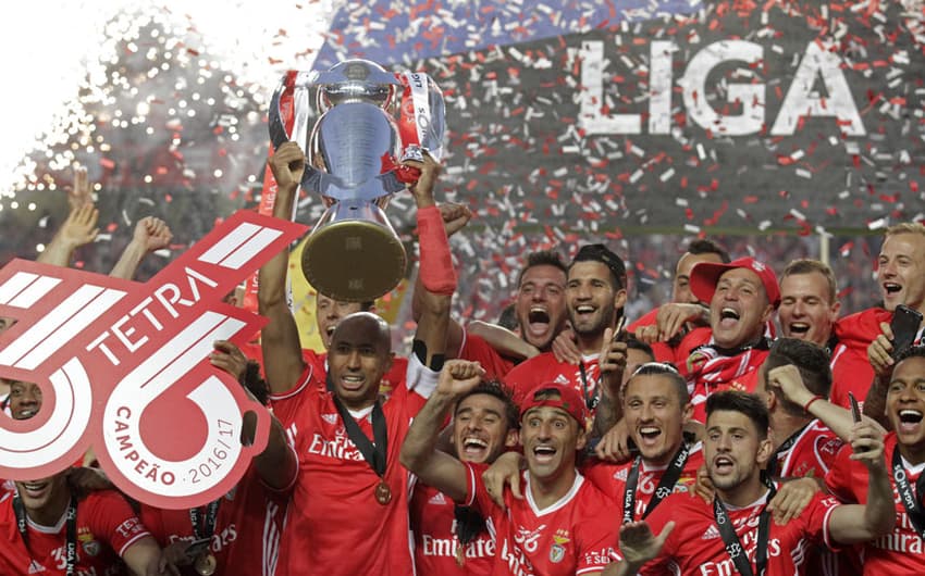 O fim de semana consagrou o Benfica como campeão português. O zagueiro e capitão Luisão ergue a taça