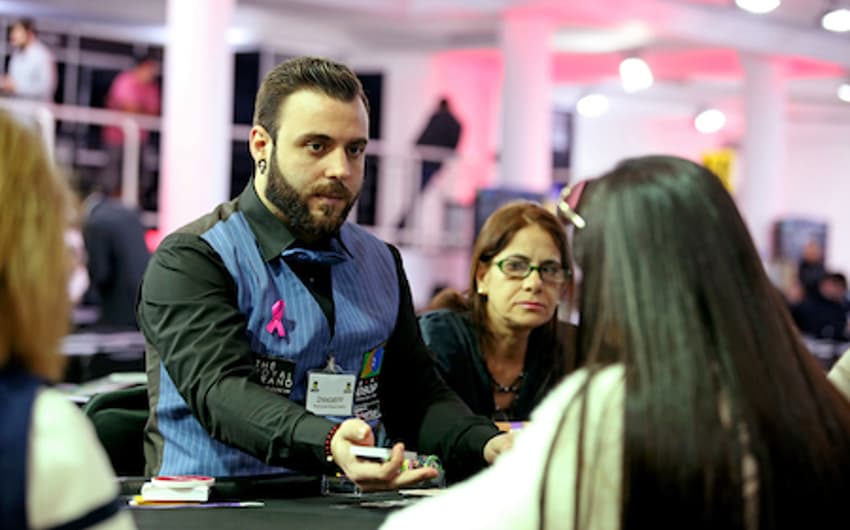 Dealer ostenta um laço rosa em homenagem à campanha mundial contra o câncer de mama