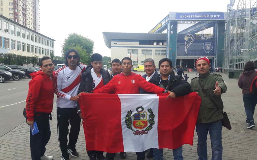Torcedores do Peru posam com a bandeira na entrada do Estádio de Khimk antes do treino aberto da seleção