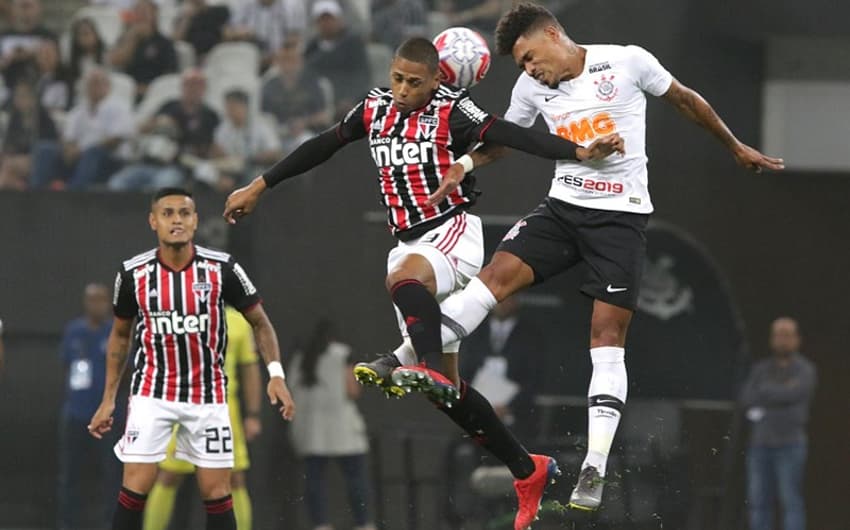 Everton, ao fundo, observa disputa de bola entre o zagueiro Bruno Alves e o volante Júnior Urso, do Corinthians