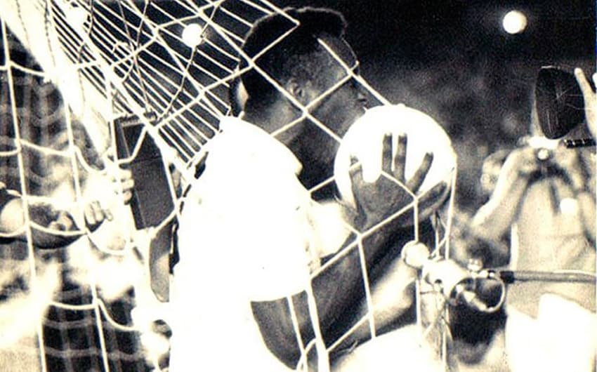 Após balançar o 'véu da noiva' do Maracanã, Pelé beija a bola com a qual marcou seu gol de número mil na carreira