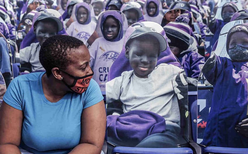 Mãe de Mo Gaba posa junto a foto do filho em sessão do estádio do Baltimore Ravens que o homenageia