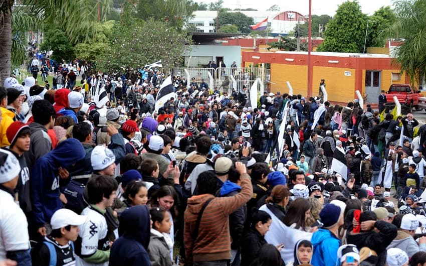 Torcida do Olimpia comemora na saída do aeroporto Silvio Pettirossi (Foto: Norberto Duarte/AFP)