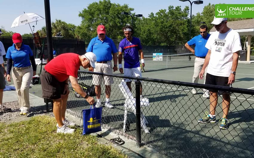 Voluntário tenta capturar cobra em quadra de torneio de tênis nos Estados Unidos