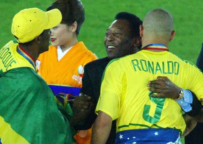 Pelé comemora a conquista do penta no gramado com o craque Ronaldo e Roque Junior