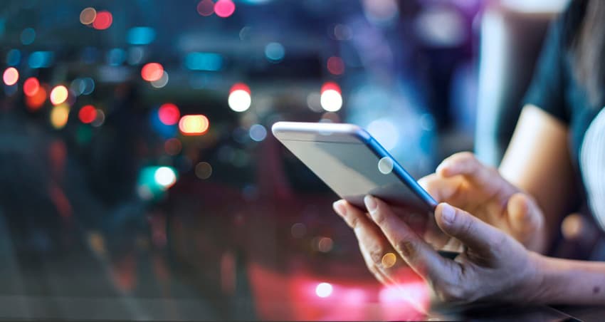 Woman using mobile smart phone in the night light colorful background