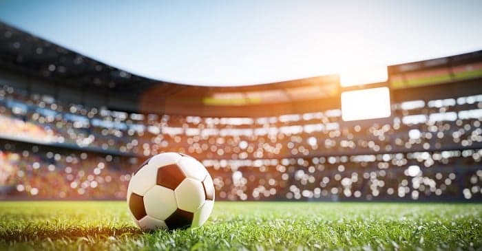 Football soccer ball on grass field on stadium