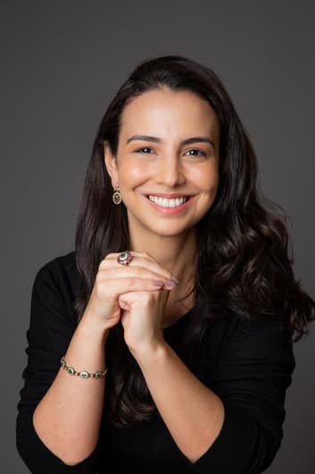 mulher branca com cabelo castanho posando para foto em estúdio 