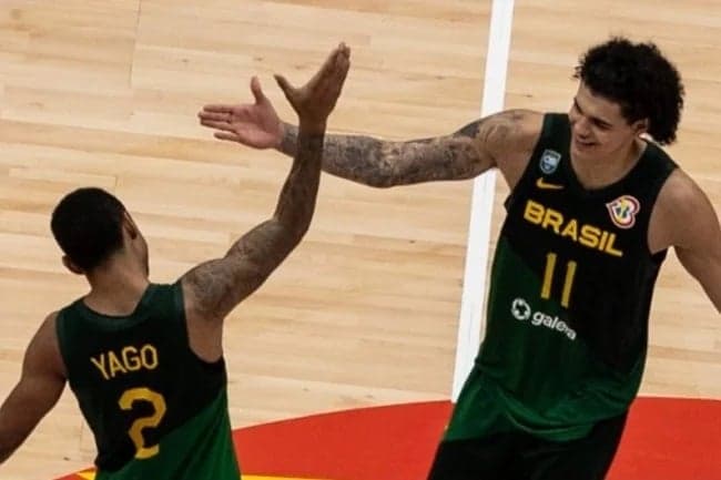Yago dos Santos e Gui Santos comemorando em jogo do Brasil na Copa do Mundo de Basquete (Foto: Yasuyoshi Chiba / AFP)