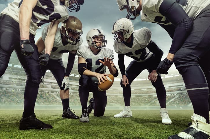 Teammates. Team of male american football players before sport match at stadium over cloudy sky background with flashlights. Collage