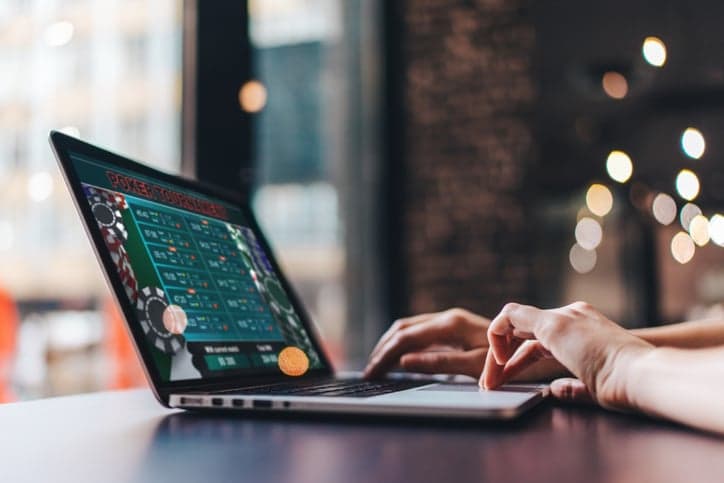 Girl using her laptop for taking part in online poker tournament