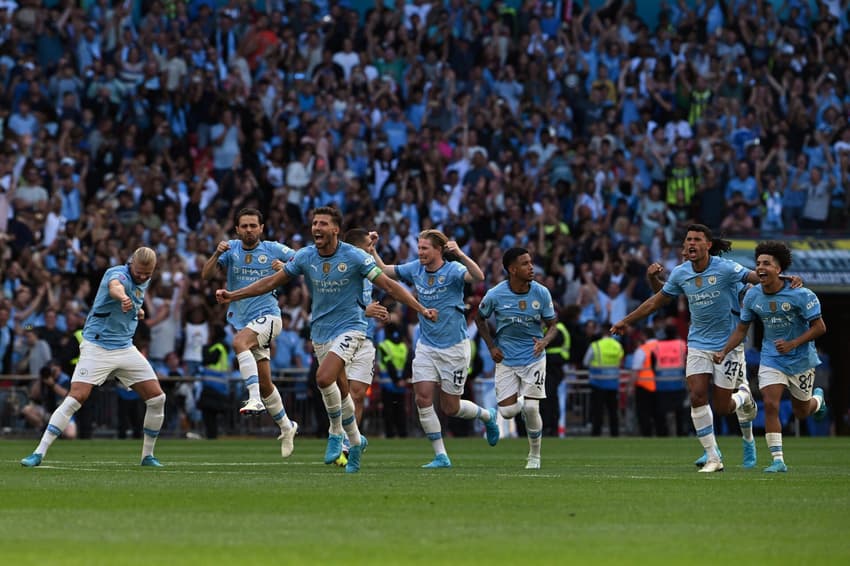 Jogadores do Manchester City comemoram título para cima do rival, Manchester United. Foto: JUSTIN TALLIS / AFP