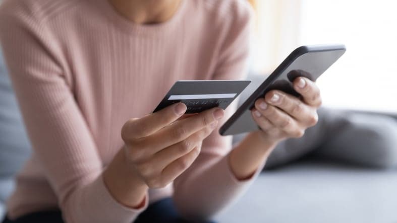 Close up female hands holding credit card and smartphone