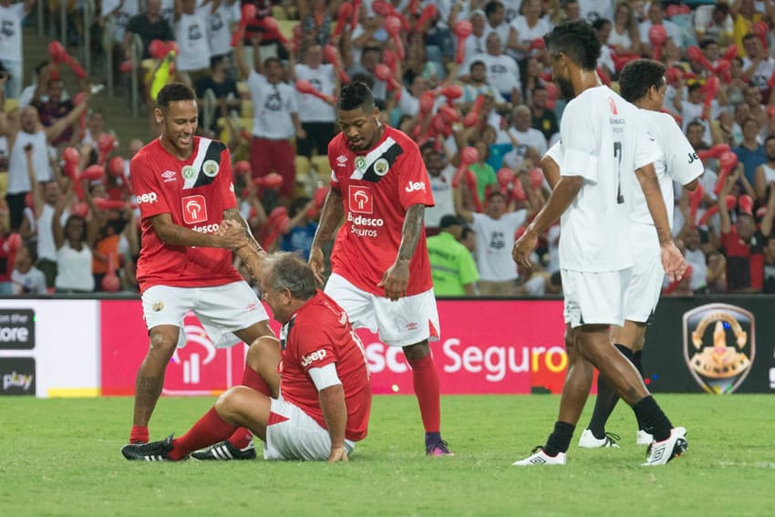 Neymar e Marinho ajudam Zico após o gol do time vermelho, durnate o Jogo das Estrelas amistoso comemorativo no Maracana