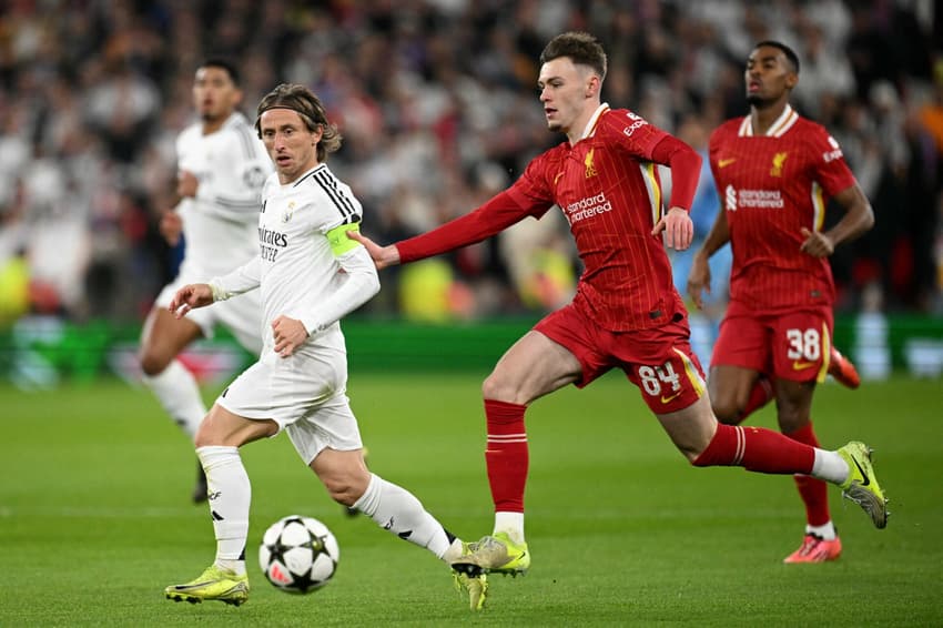 Conor Bradley, que entrou no lugar de Arnold, do Liverpool, e Luka Modric, do Real Madrid, disputam bola em jogo pela Champions League