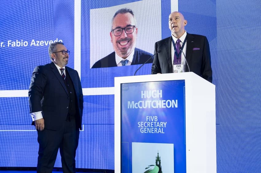 O novo presidente Fábio Azevedo assiste ao discurso do novo secretário-geral da Federação Internacional de Vôlei, Hugh McCutcheon