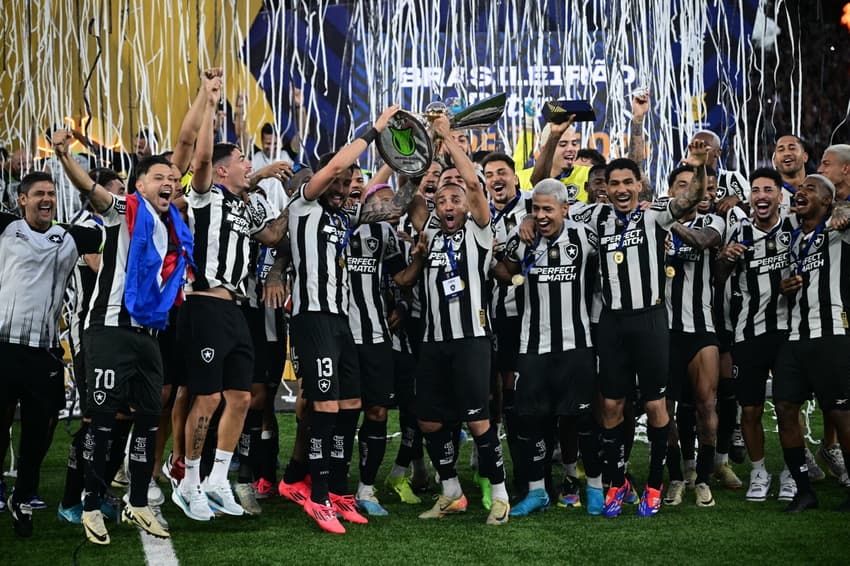 Jogadores do Botafogo comemoram com a taça de campeão brasileiro no Nilton Santos. (foto: Mauro PIMENTEL / AFP)