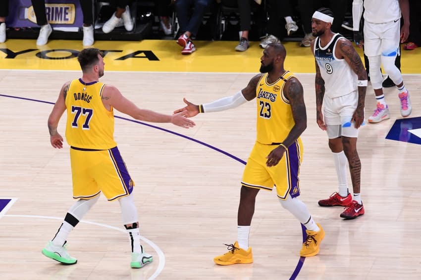 Luka Doncic e LeBron James, do Los Angeles Lakers, se cumprimentam em jogo contra o Minnesota Timberwolves pela NBA (Foto: Juan Ocampo/NBAE via Getty Images/AFP)