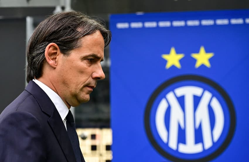 Simone Inzaghi caminha com o escudo da Inter de Milão ao fundo (Foto: Piero Cruciatti/AFP)