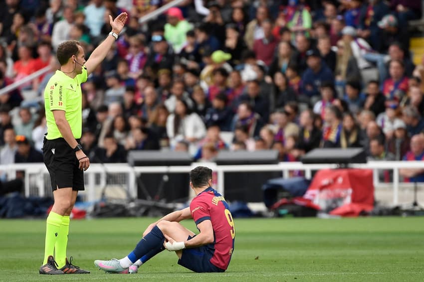 Lewandowski caído no gramado e com a mão no músculo posterior da coxa esquerda em Barcelona x Celta de Vigo