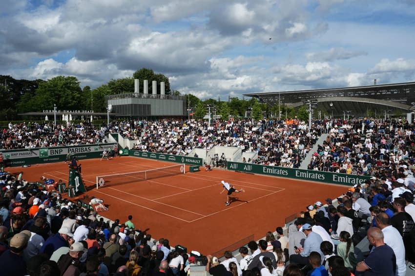 Hungary's Marton Fucsovics (R) serves to US Tommy Paul during their men's singles match on day 4 of the French Open tennis tournament at the Roland-Garros Complex in Paris on May 28, 2025. (Photo by Dimitar DILKOFF / AFP)