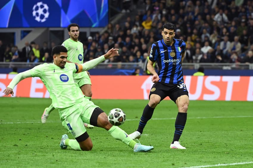 Ronaldo Araujo e Taremi disputando a bola no confronto entre Inter de Milão e Barcelona, pela Champions League. (Foto: Piero Cruciatti/AFP)