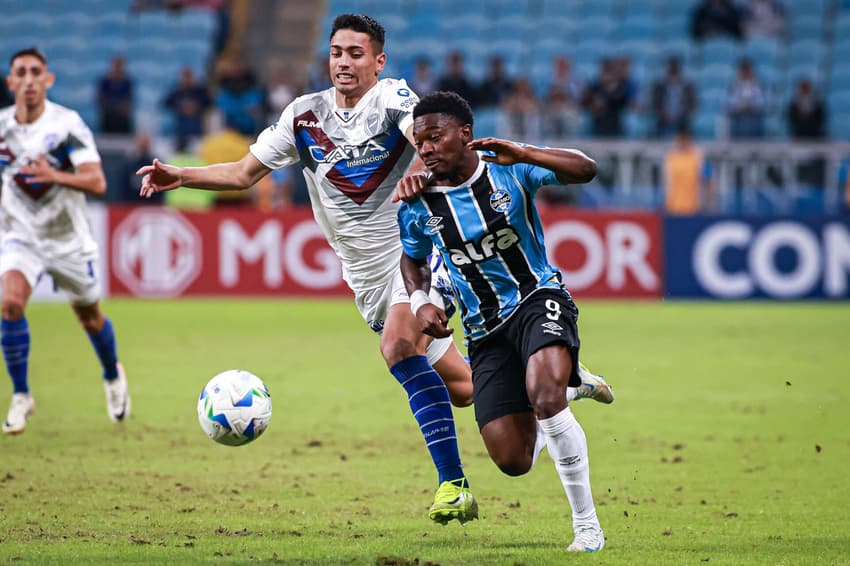 Amuzu e Arce em disputa de bola no jogo entre Grêmio e Godoy Cruz. (Foto: Maxi Franzoi/AGIF)