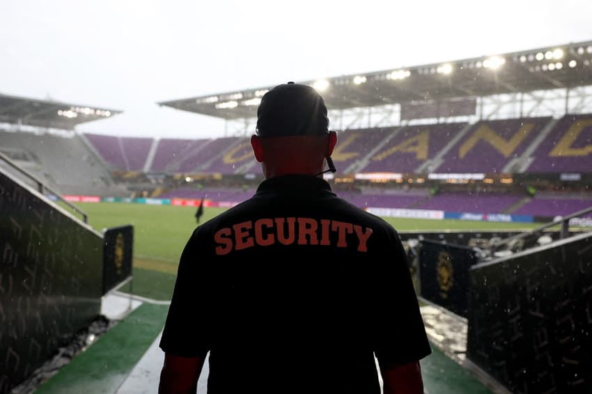 Segurança oberva o tempo ruim no estádio do Orlando durante a paralisação de Benfica x Auckland (Foto: ALEX GRIMM / GETTY IMAGES NORTH AMERICA / Getty Images via AFP)