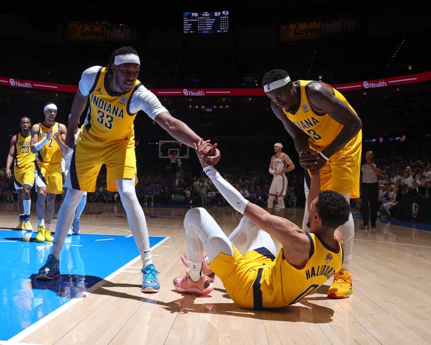 Myles Turner e Pascal Siakam ajudam Tyrese Haliburton durante jogo entre Pacers e Thunder pelas finais da NBA (Foto: Nathaniel S. Butler/NBAE via Getty Images/AFP)