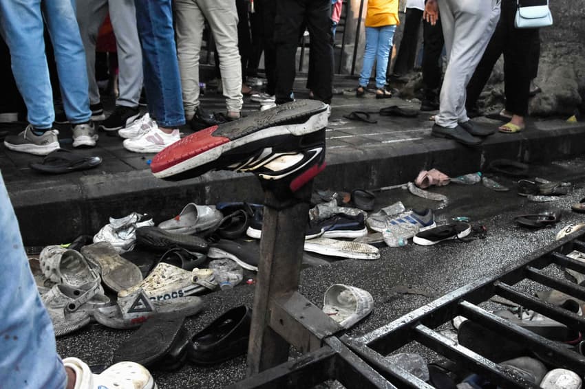 Sapatos das vítimas abandonados após tumulto em partida de críquete em Bengaluru (foto: AFP)