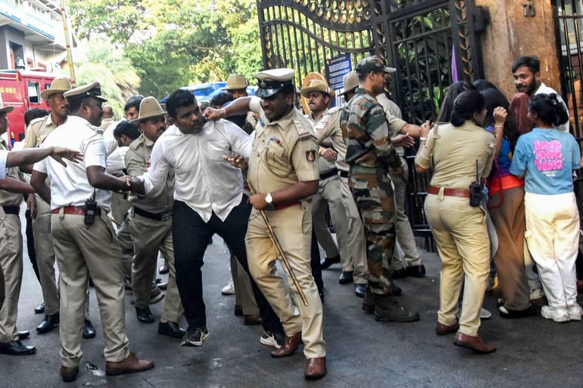 Seguranças tentam cnter os trocedores do lado de fora do Chinnaswamy Stadium em torneio de críquete (foto: AFP)