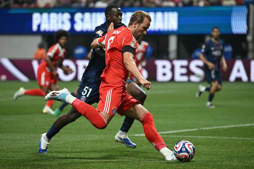 Harry Kane e Pacho disputam a bola em PSG x Bayern (Foto: Paul ELLIS / AFP)