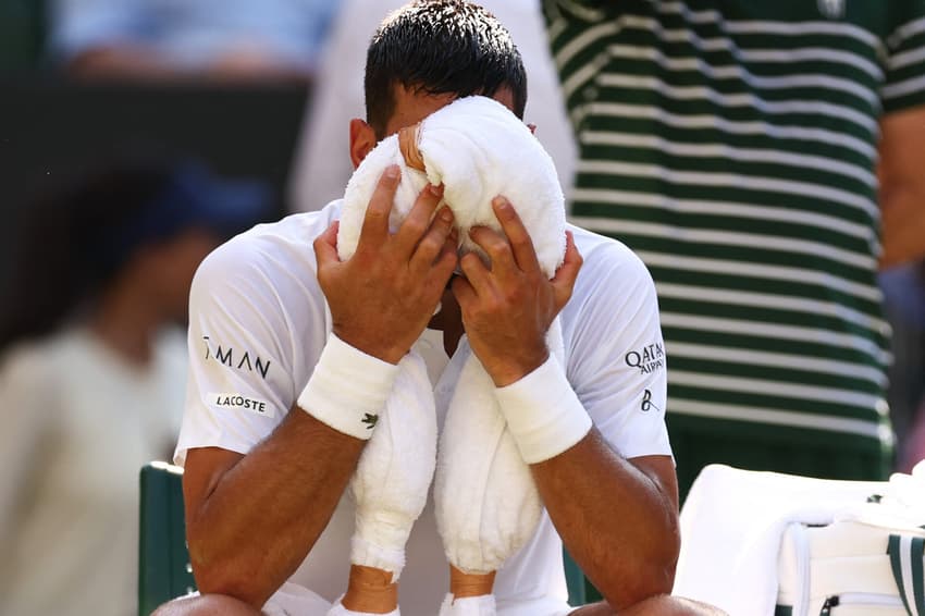 Novak Djokovic tenta aliviar o calor na partida contra o líder do ranking, Jannik Sinner (Foto: HENRY NICHOLLS / AFP)