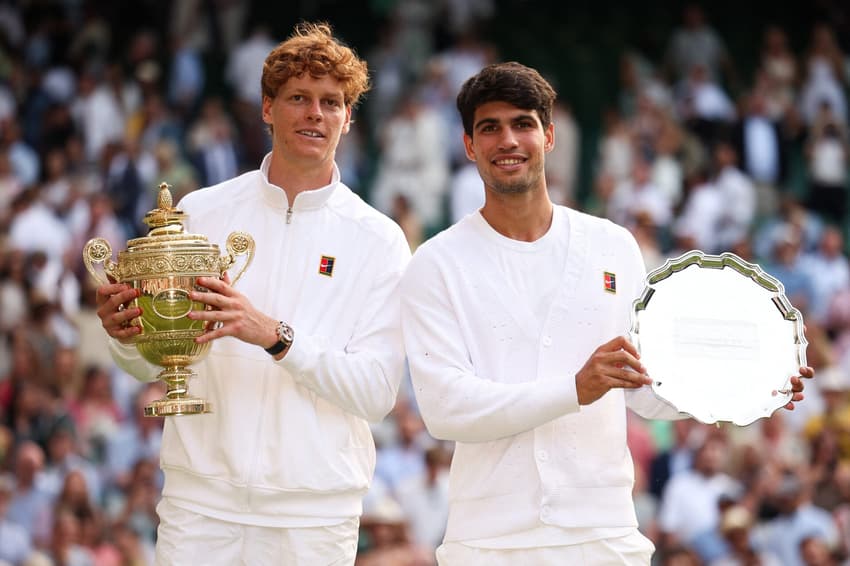 O italiano Jannik Sinner e o espanhol Carlos Alcaraz com os troféus de Wimbledon (Foto: HENRY NICHOLLS / AFP)