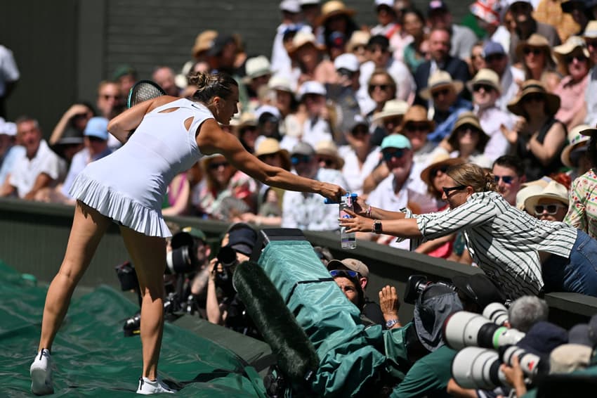 Aryna Sabalenka dá água para um torcedor em Wimbledon (foto: Glyn KIRK / AFP)