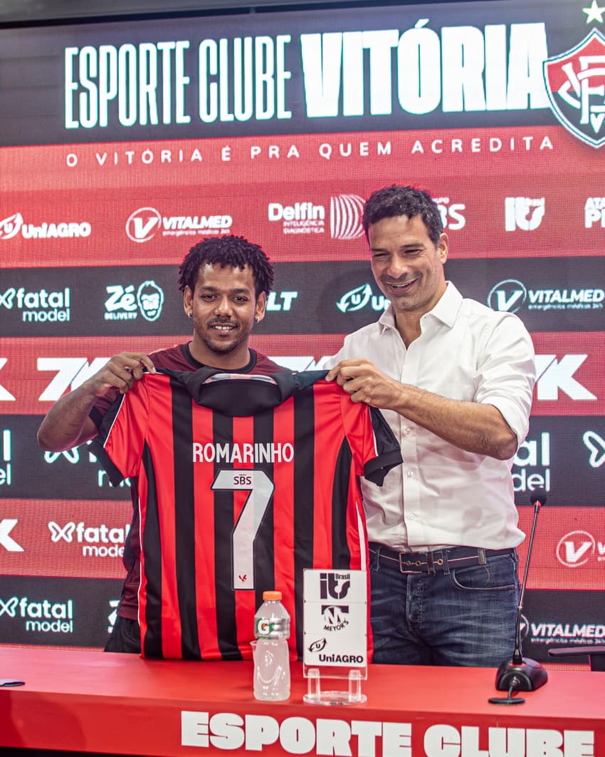 Romarinho com sua nova camisa ao lado do executivo de futebol Gustavo Vieira (Foto: Victor Ferreira / EC Vitória)