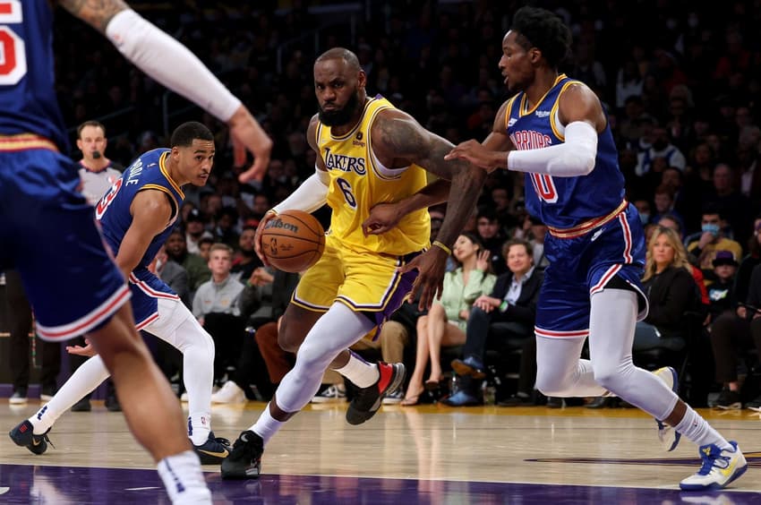 LeBron James, do Lakers, em disputa contra Jonathan Kuminga, do Warriors, pela NBA (Foto: AFP)
