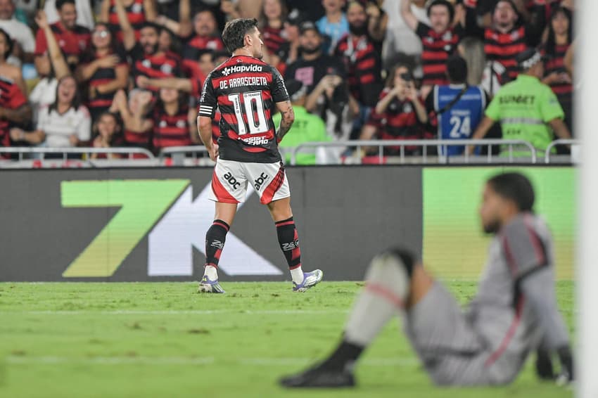 Arrascaeta comemora gol do Flamengo diante de um Lucas Arcanjo abatido (Foto: Thiago Ribeiro/AGIF)